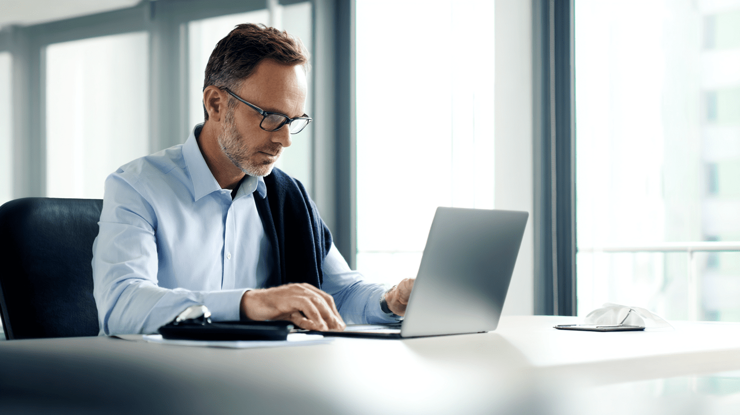 Przedsiębiorca w biurze dokonuje zgłoszenia do Centralnego Rejestru Beneficjentów Rzeczywistych, wypełniając formularz online na laptopie.