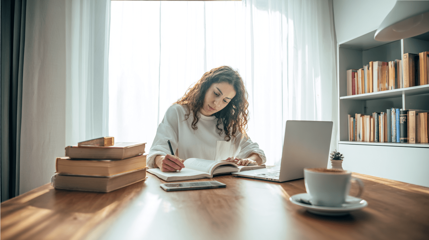Studentka psychologii podczas nauki zdalnej przy biurku z laptopem i podręcznikami w ramach studiów online.
