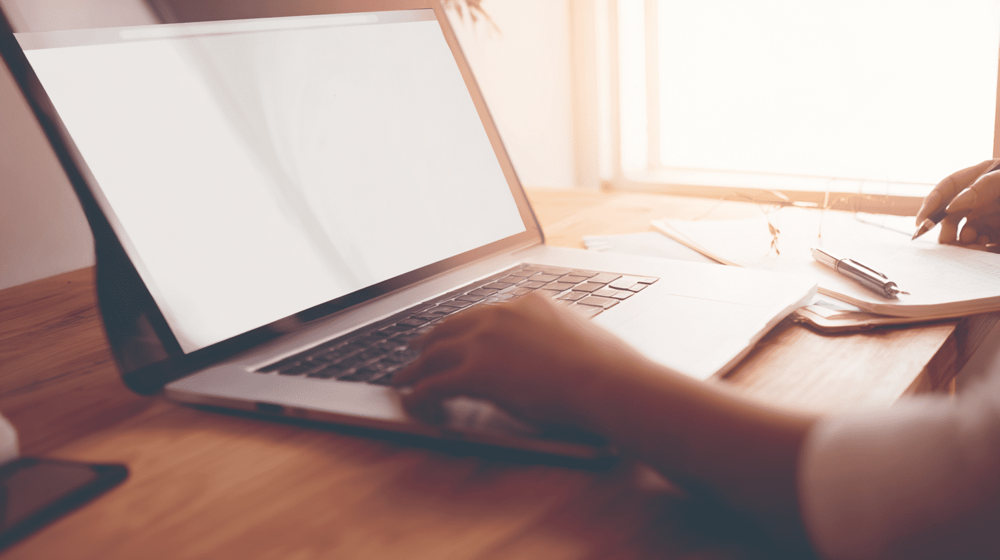 Osoba pracująca na nowym laptopie przy biurku, ilustrująca PFRON dofinansowanie do laptopa i składanie wniosków online.